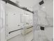 Modern bathroom with marble-look shower, glass door and double vanity with black fixtures at 106 Corbett Rd, Lithia, FL 33547