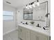 Bathroom featuring dual sinks, sleek fixtures, and a modern lighting fixture at 106 Corbett Rd, Lithia, FL 33547