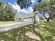 Rear view showing the light green stucco home with a two car garage and timber shutters on the windows at 106 Corbett Rd, Lithia, FL 33547