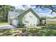 Side view of light green stucco home with a 2 car garage, timber shutters and landscaping along the walkway at 106 Corbett Rd, Lithia, FL 33547