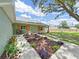 Exterior showcasing light green home with timber posts and shutters over the windows surrounded by a well landscaped yard at 106 Corbett Rd, Lithia, FL 33547