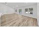 Open-concept living room with wood-look floors and large windows, letting in lots of natural light at 106 Corbett Rd, Lithia, FL 33547
