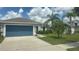 Well-maintained home with a blue garage door, palm trees, and a manicured lawn at 13443 Graham Yarden Dr, Riverview, FL 33579