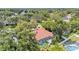An aerial view of the property showcasing the house, screened pool, landscaping, and surrounding trees at 2332 Timbergrove Dr, Valrico, FL 33596