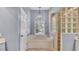 Relaxing bathroom featuring a soaking tub under a window and unique glass block shower at 2332 Timbergrove Dr, Valrico, FL 33596