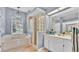 Bright bathroom with a glass block shower, soaking tub and vanity with sink at 2332 Timbergrove Dr, Valrico, FL 33596