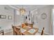 View of the dining room featuring a rustic table with seating for six, views into other living spaces, and modern lighting at 2332 Timbergrove Dr, Valrico, FL 33596