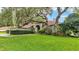 Inviting home exterior with manicured lawn, mature trees, and lush landscaping in a desirable neighborhood at 2332 Timbergrove Dr, Valrico, FL 33596