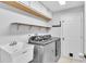 Well-lit laundry room with a washing machine, dryer, utility sink, and shelving at 2332 Timbergrove Dr, Valrico, FL 33596