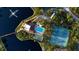 Aerial view of a lake surrounded by lush landscaping, pool, and tennis courts at 23465 Harborview Rd # 223, Punta Gorda, FL 33980