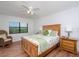 Comfortable bedroom with a ceiling fan, a serene view, and warm wood floors at 23465 Harborview Rd # 223, Punta Gorda, FL 33980