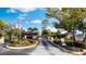 Gated community entrance with lush landscaping and American flag flying at 23465 Harborview Rd # 223, Punta Gorda, FL 33980