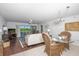 Inviting condo living room with balcony access, ceiling fan, and open-concept dining area at 23465 Harborview Rd # 223, Punta Gorda, FL 33980