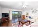 Inviting living room with sliding glass doors to a balcony, hardwood floors, and a ceiling fan at 23465 Harborview Rd # 223, Punta Gorda, FL 33980