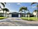 Modern home with a sleek design, palm trees, well-manicured lawn, and a spacious driveway at 320 Palm Ne Is, Clearwater Beach, FL 33767
