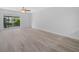 A bedroom with wood-look floors has access to a screened balcony at 3811 N Oak Dr # E62, Tampa, FL 33611