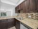 This is a kitchen with granite counters, stainless steel appliances, and views to the living room at 3811 N Oak Dr # E62, Tampa, FL 33611