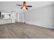 This is a brightly lit living room with grey wood-look floors and a ceiling fan at 3811 N Oak Dr # E62, Tampa, FL 33611