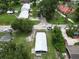 An aerial view of a charming home with a metal roof surrounded by lush greenery and mature trees at 702 Hillsboro St, Plant City, FL 33563