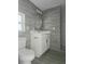Modern bathroom features gray tile walls, stylish vanity, round mirror and tiled shower at 702 Hillsboro St, Plant City, FL 33563