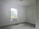 Bright bedroom featuring hardwood floors and a window unit for efficient cooling at 702 Hillsboro St, Plant City, FL 33563