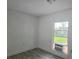 Cozy bedroom with wood-look flooring, white walls, and natural light from the window at 702 Hillsboro St, Plant City, FL 33563