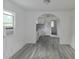 Dining room showcasing gray wood-look flooring and an arched doorway to the kitchen at 702 Hillsboro St, Plant City, FL 33563