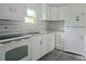 Kitchen featuring stainless appliances, white cabinets, and patterned backsplash at 702 Hillsboro St, Plant City, FL 33563