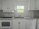 Bright kitchen featuring stainless steel appliances, granite countertops, and white cabinets at 702 Hillsboro St, Plant City, FL 33563