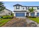 Two-story home with blue garage doors and landscaped yard at 5657 Tripoli Dr, Palmetto, FL 34221