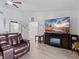 Spacious living room featuring a large TV and comfortable leather seating at 13473 Bruni Dr, Spring Hill, FL 34609
