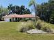 Inviting single-story home with a terracotta roof, two-car garage, a palm tree, and a meticulously maintained lawn at 1608 Bob O Link Dr, Venice, FL 34293