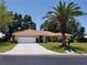Attractive single-story home featuring a terracotta tile roof, two-car garage, and a tall palm tree in the front yard at 1608 Bob O Link Dr, Venice, FL 34293