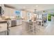 Bright, modern kitchen featuring stainless steel appliances, a central island, and an open layout to the living area at 18039 Cherished Loop, Bradenton, FL 34211