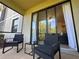 Screened patio with wicker chairs and a small glass-top table at 7121 River Hammock Dr # 107, Bradenton, FL 34212