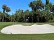 Golfer putting on a green with sand trap at 7121 River Hammock Dr # 107, Bradenton, FL 34212