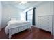 Bedroom with white bed frame and dresser, hardwood floors at 7121 River Hammock Dr # 107, Bradenton, FL 34212