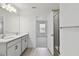 Bathroom with double sinks, white cabinetry, and a glass-enclosed shower at 7424 Cabin Ln, Sarasota, FL 34240