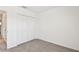 Bedroom with neutral carpet and a closet with white bi-fold doors on a white wall at 7424 Cabin Ln, Sarasota, FL 34240