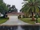 Single-story home with a red tile roof, white garage door, and a palm tree at 1608 Bob O Link Dr, Venice, FL 34293