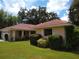 Tan house with red tile roof, lush landscaping, and a two-car garage at 1608 Bob O Link Dr, Venice, FL 34293