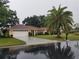 Single-story home with a two-car garage and palm tree at 1608 Bob O Link Dr, Venice, FL 34293