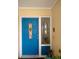 Inviting blue front door accented with a 'Welcome Home' sign and wreath at 1608 Bob O Link Dr, Venice, FL 34293