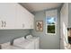 Laundry room featuring washer, dryer, and upper cabinets at 289 Vistera Blvd, Nokomis, FL 34275