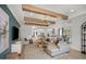 Open living room with wood beams, neutral furniture, and a teal accent wall at 289 Vistera Blvd, Nokomis, FL 34275