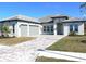 Beautiful single-story home featuring a paver driveway, two-car garage, and well-manicured landscaping at 13378 Amargo Ct, Venice, FL 34293