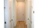 Clean hallway features neutral walls, wood flooring, and paneled doors with modern hardware, enhancing the home's contemporary appeal at 232 Vistera Blvd, Nokomis, FL 34275