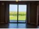 Living area with tile flooring, sliding glass door, and view of trees at 14071 Heritage Landing Blvd # 334, Punta Gorda, FL 33955