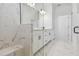 Elegant bathroom with marble tile, double vanity, and glass shower at 18011 Cherished Loop, Bradenton, FL 34211