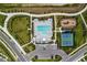 Aerial view of a community pool, clubhouse, playground, tennis courts, and parking lot at 7440 Cabin Ln, Sarasota, FL 34240